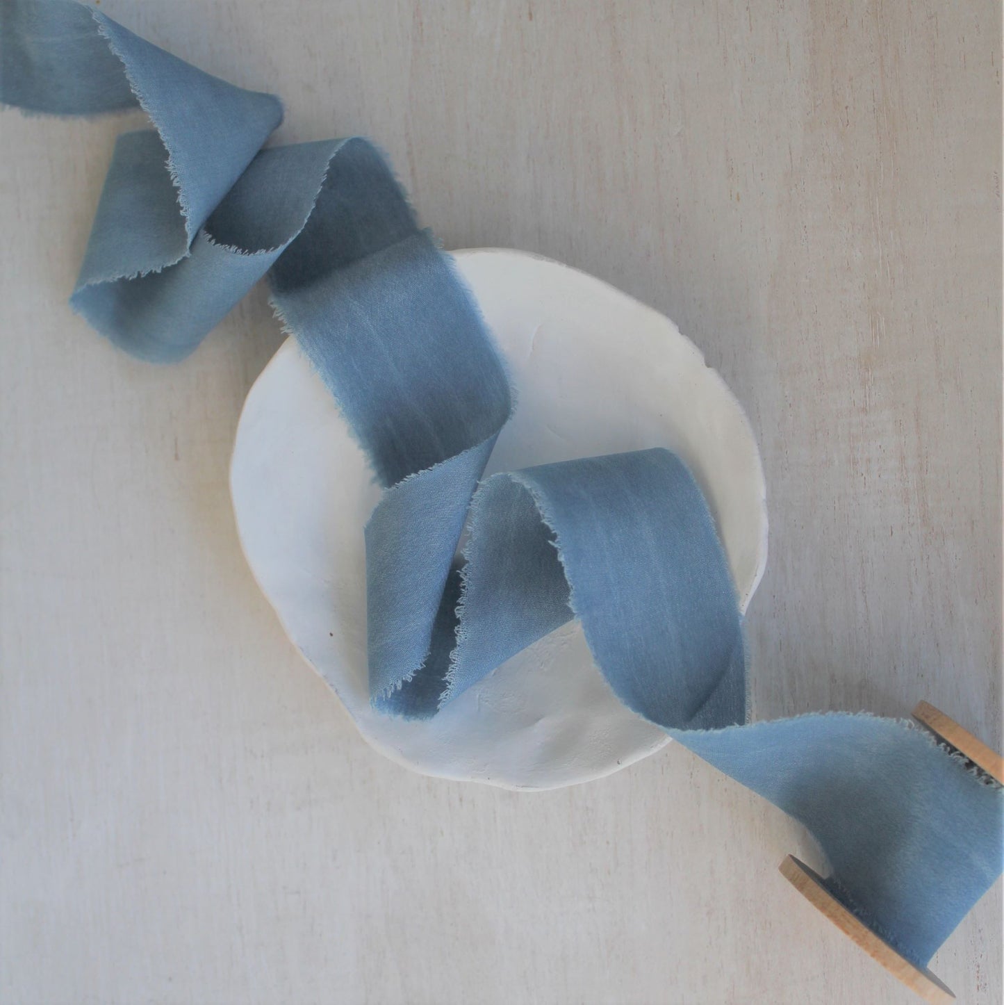 Texture detail of blue silk crepe de chine ribbon.