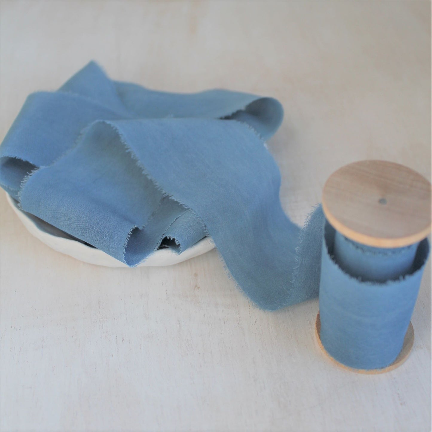 Texture detail of blue silk crepe de chine ribbon.