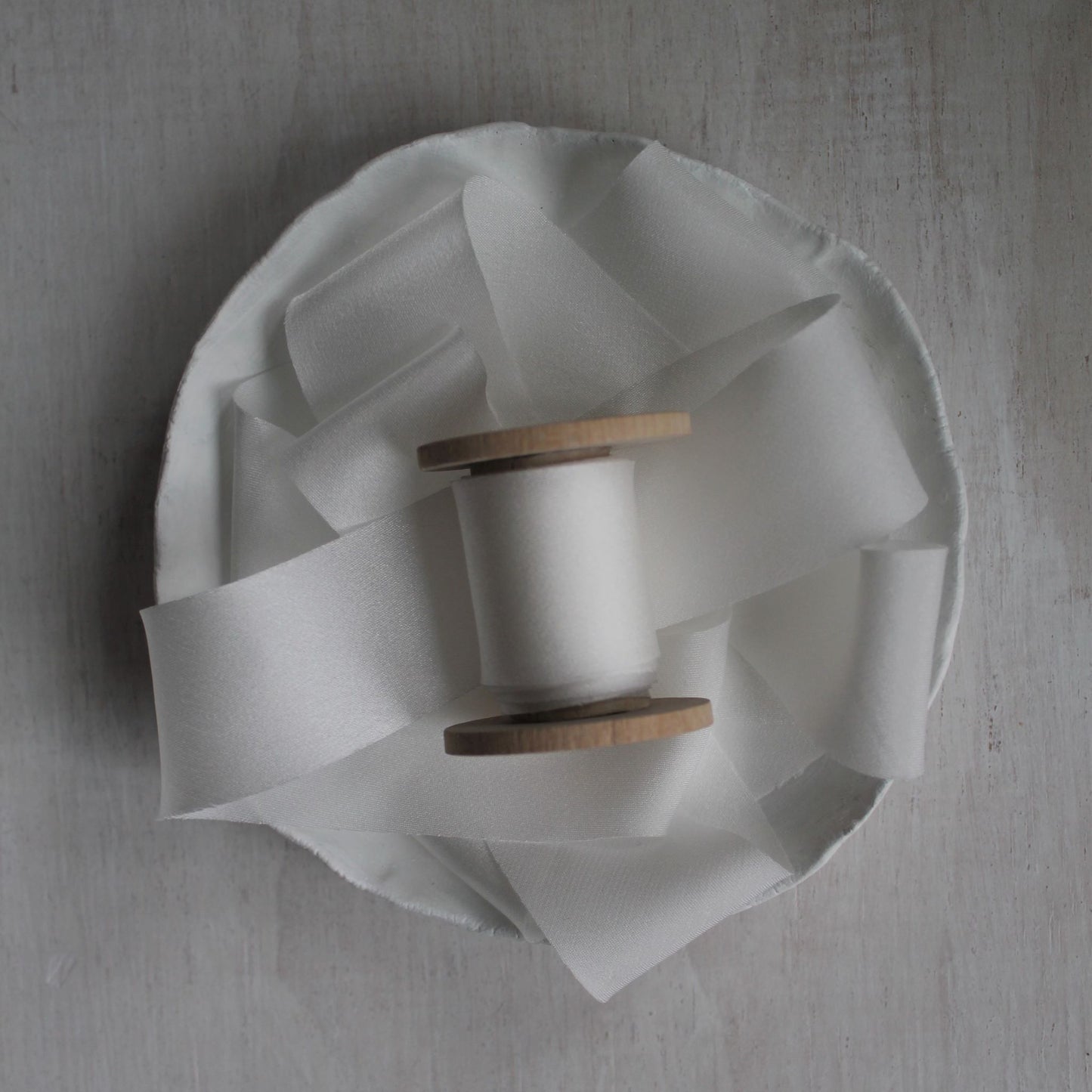Unspooled white silk ribbon with subtle sheen