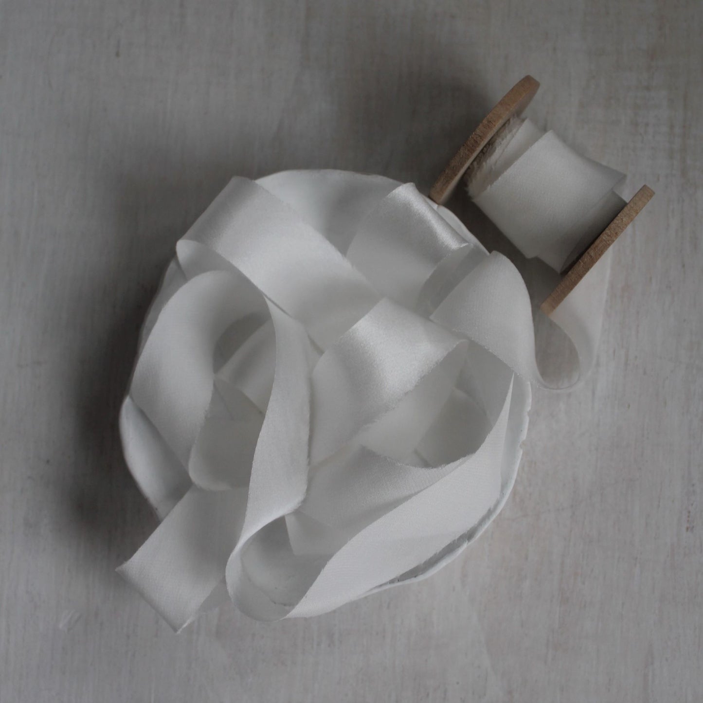 Bias-cut white ribbon edge detail highlighting clean cut