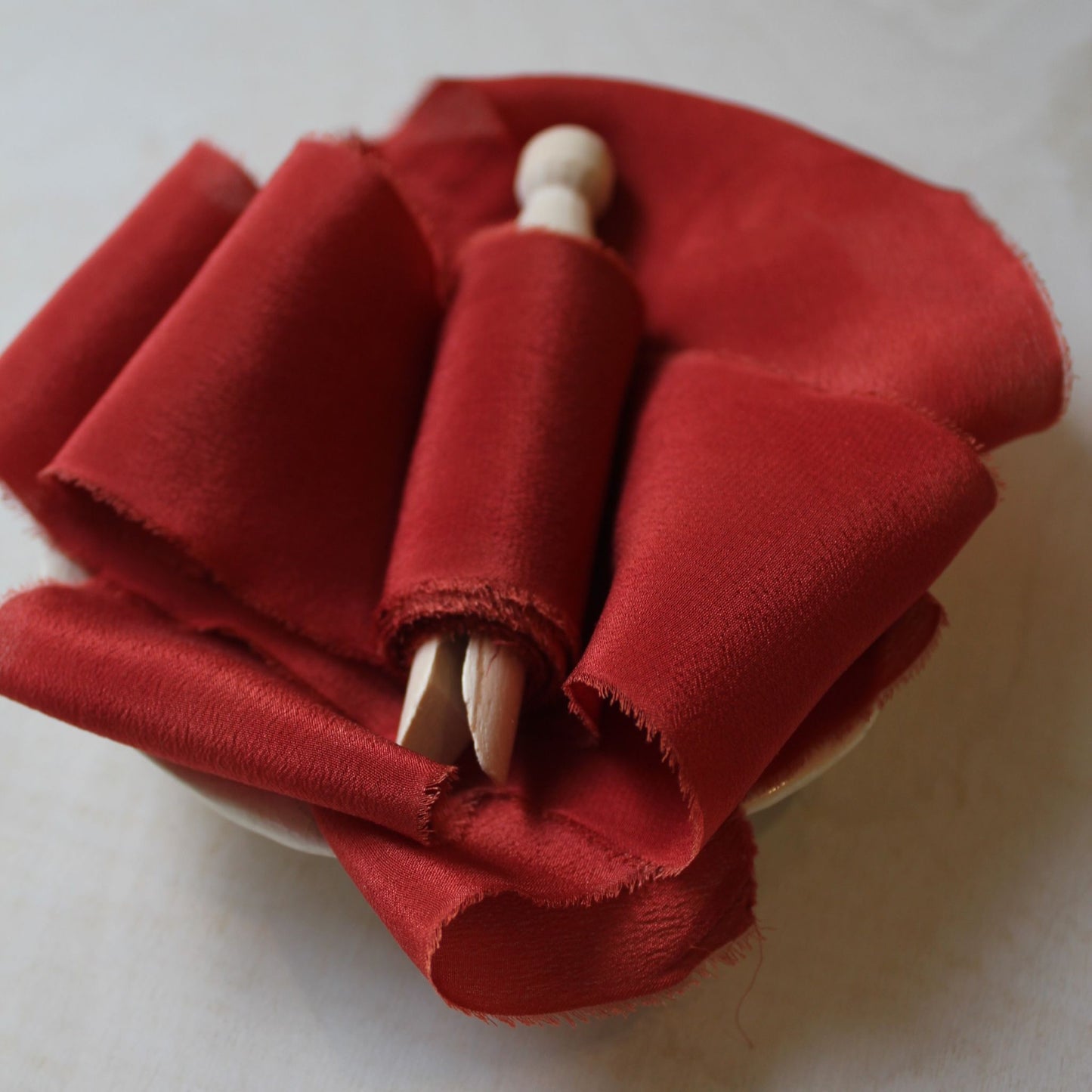 Close-up of vibrant Christmas red silk ribbon with soft, feathered edges.