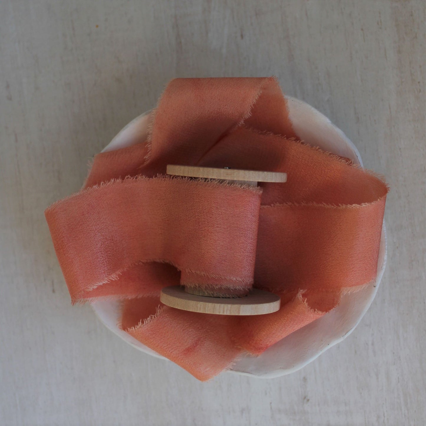 Bright pink silk crepe de chine ribbon with a hand-torn edge, dyed with natural dyes for an eco-friendly touch.