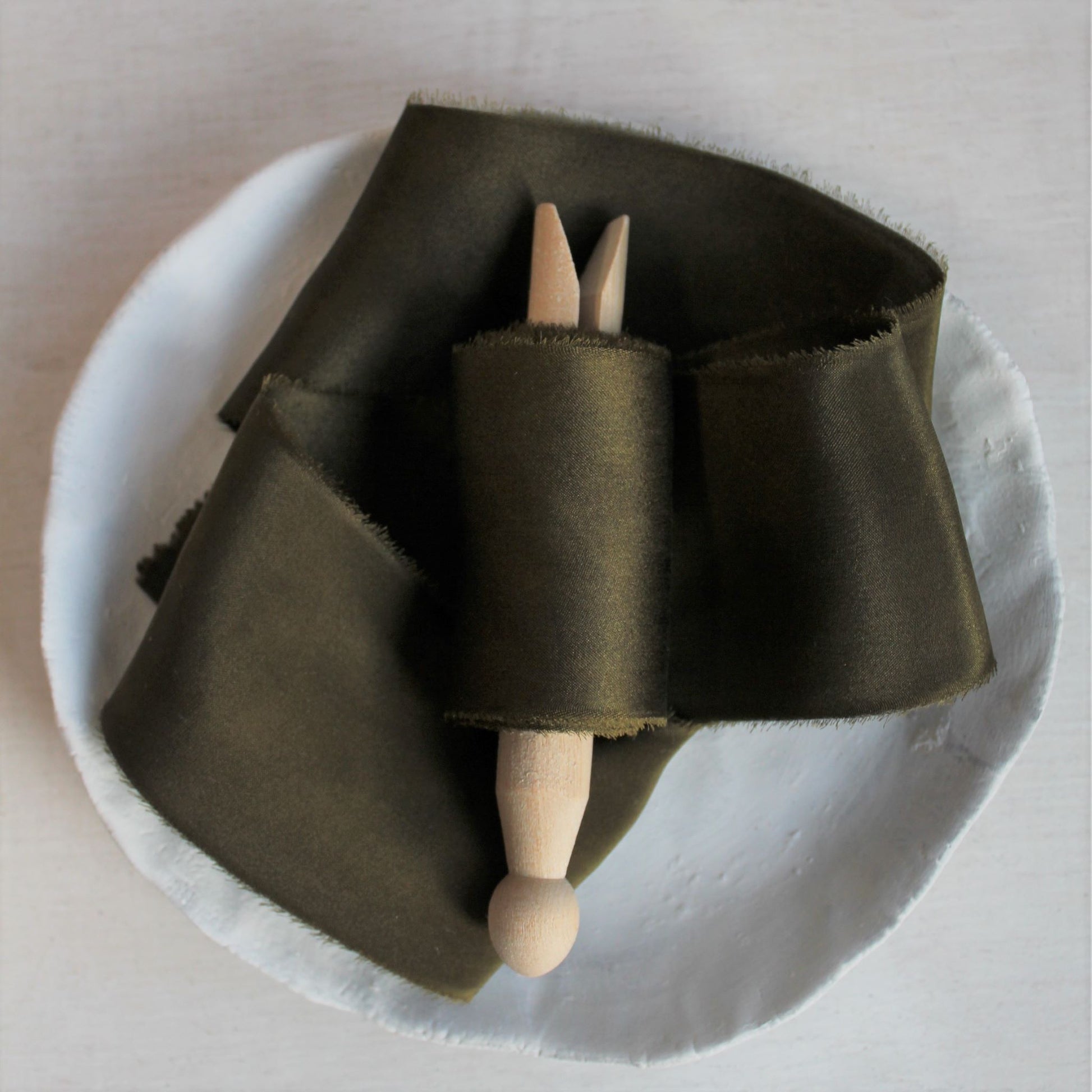 Dark moss silk charmeuse hand-torn ribbon on wooden clothes peg
